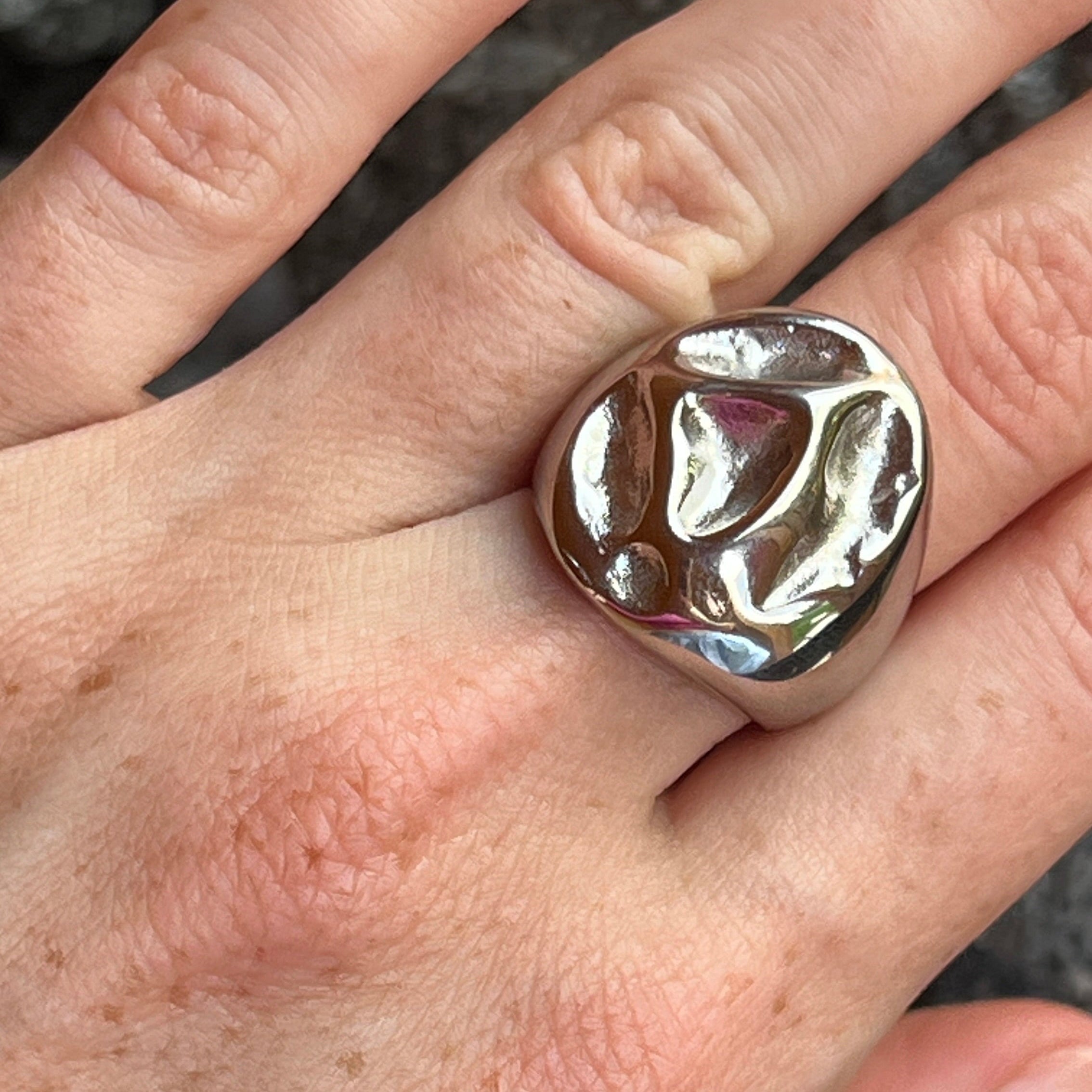 Close-up of the irregular bold chunky ring in PVD-coated 925 silver-plated stainless steel worn on a hand