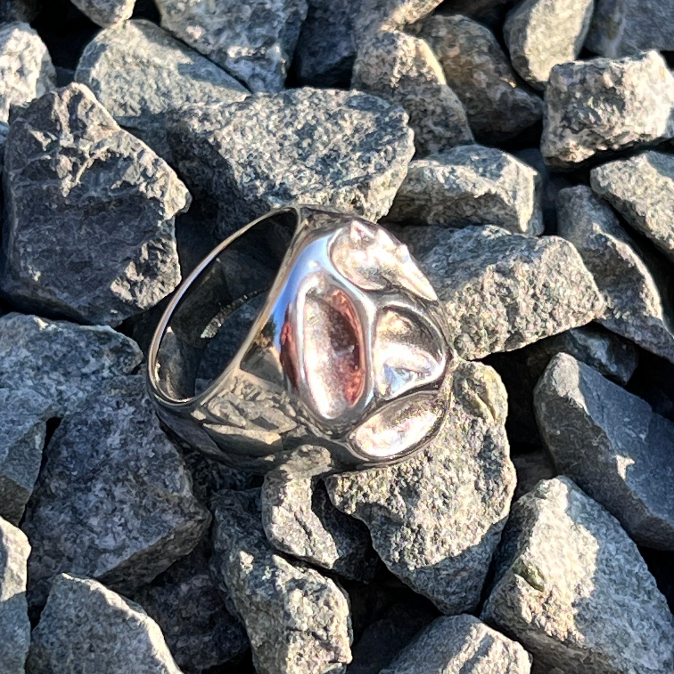 Irregular bold chunky ring in PVD-coated 925 silver-plated stainless steel styled on a bed of grey stones
